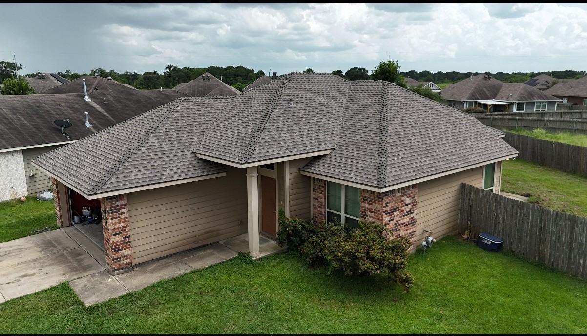 Tan brick home with new roof and driveway